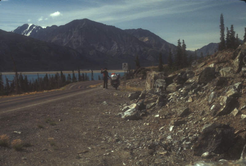 ak-17-07 self-portrait by road, lake and mountains